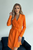 Chic navy dress with v-neck, belt, and asymmetrical hem.